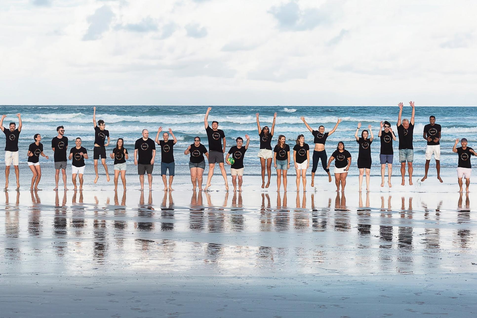 Team jump on the beach cropped